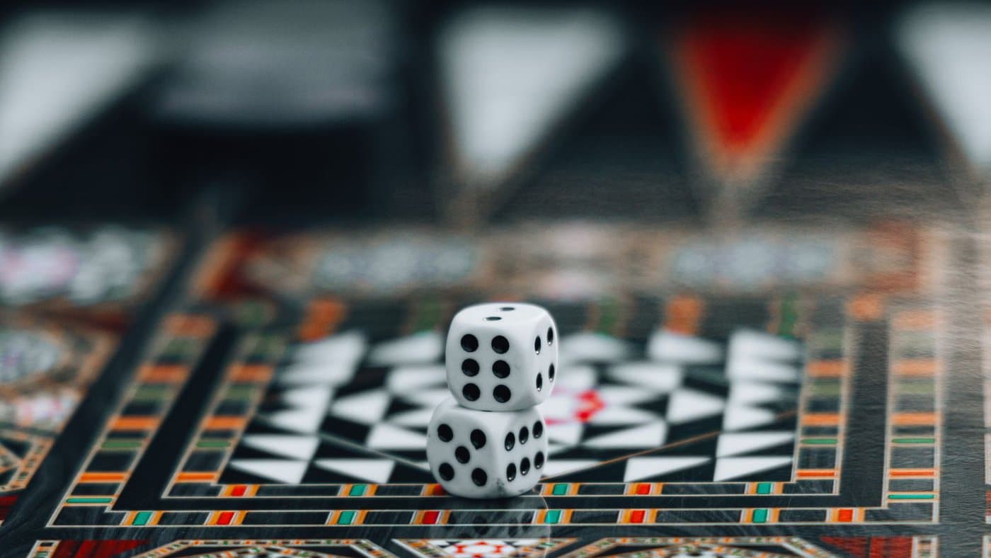 Two dice in close focus on an ornate backgammon board.